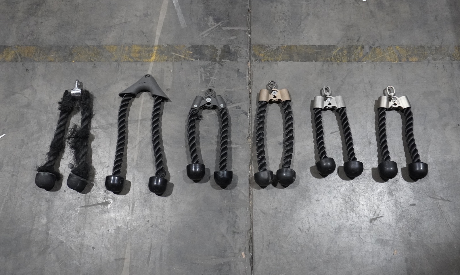 Six Adonai rope attachment prototypes laid out on a warehouse floor
